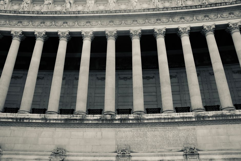 Low-angle shot of a neoclassical government building facade with marble columns.