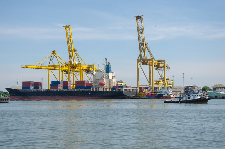 Cargo ship at a busy industrial port