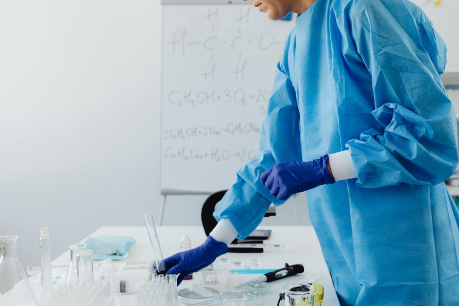 Scientist in protective clothing working in laboratory