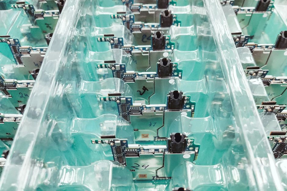 A close-up view of organized green electronic circuit boards on a factory production line.