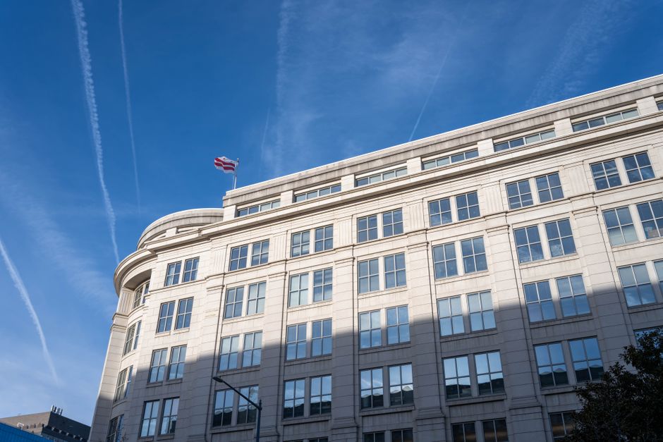 A modern office building with a glass facade under a clear blue sky in Washington, D.C., representing the regulatory seat of US equity market oversight.