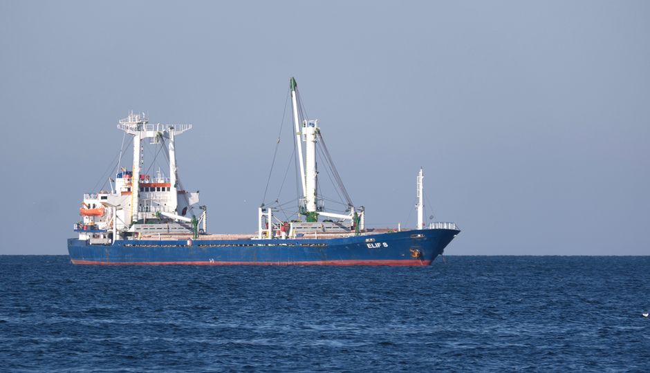 A large blue cargo ship sails across the open sea, illustrating maritime petroleum and freight transport through critical shipping lanes.
