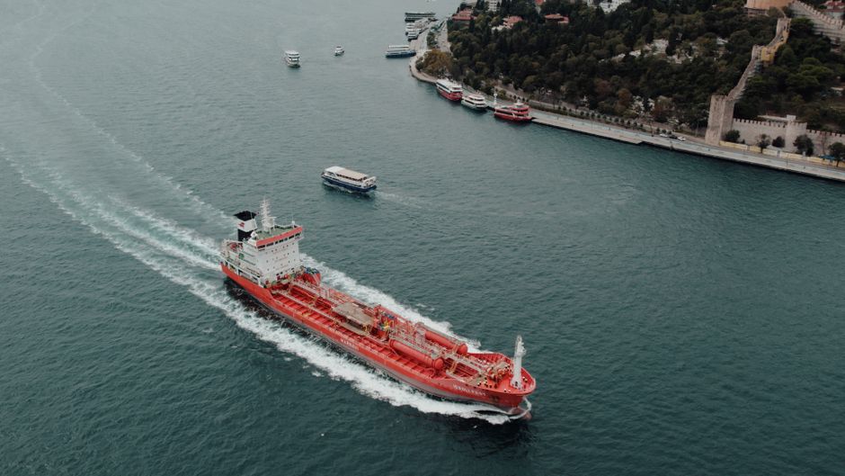 Cargo ship navigating a narrow maritime chokepoint.