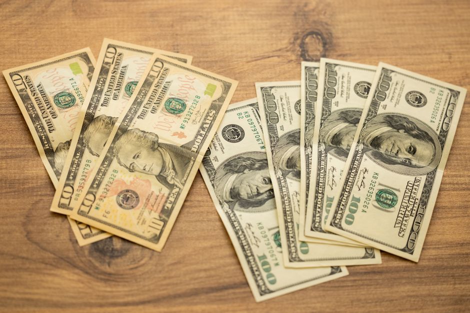US dollar bills arranged on a wooden surface