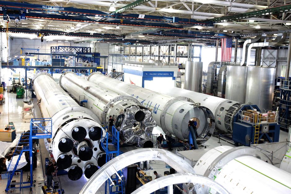 A spacecraft assembly hangar with rockets in a spacious industrial facility