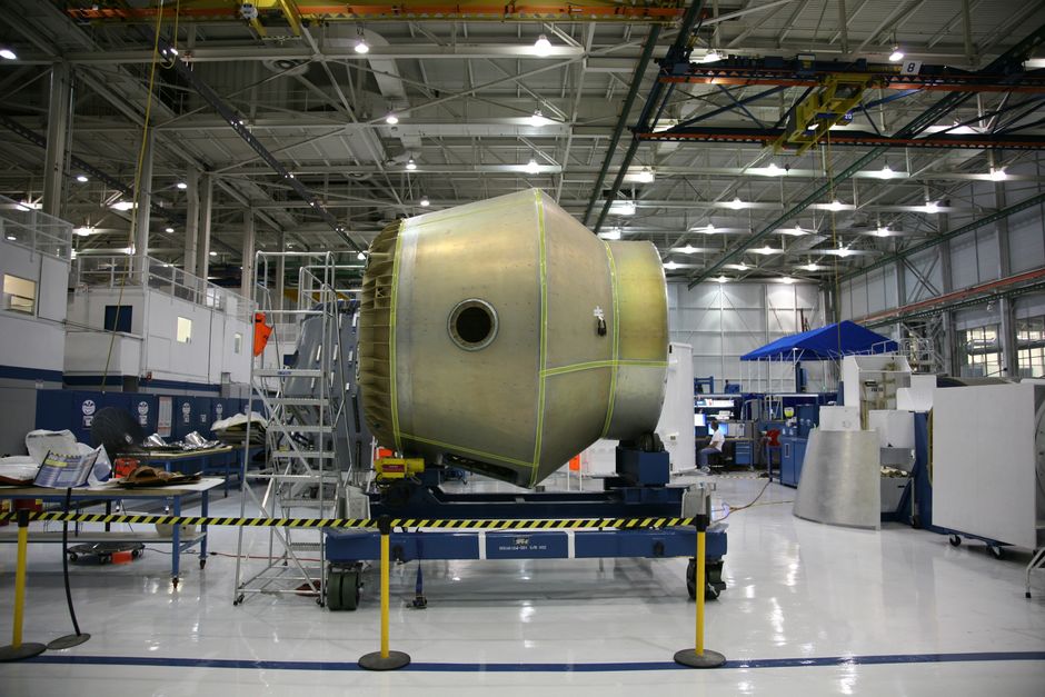 Spacecraft under construction on a rolling platform in a rocket factory