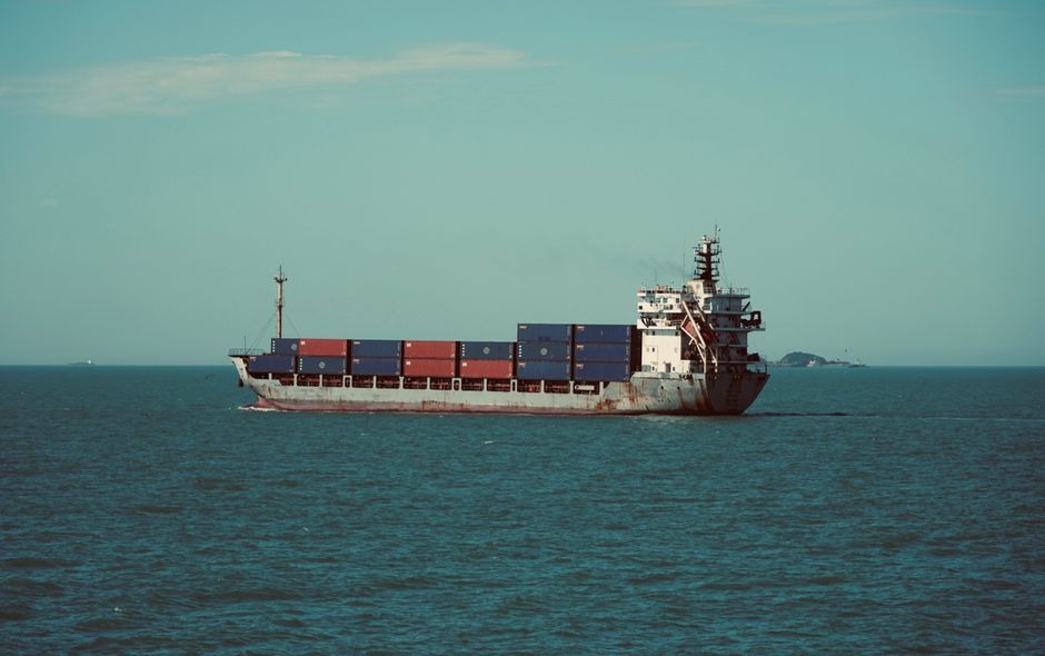 Cargo ship carrying containers across an open sea as energy and shipping risks intensify