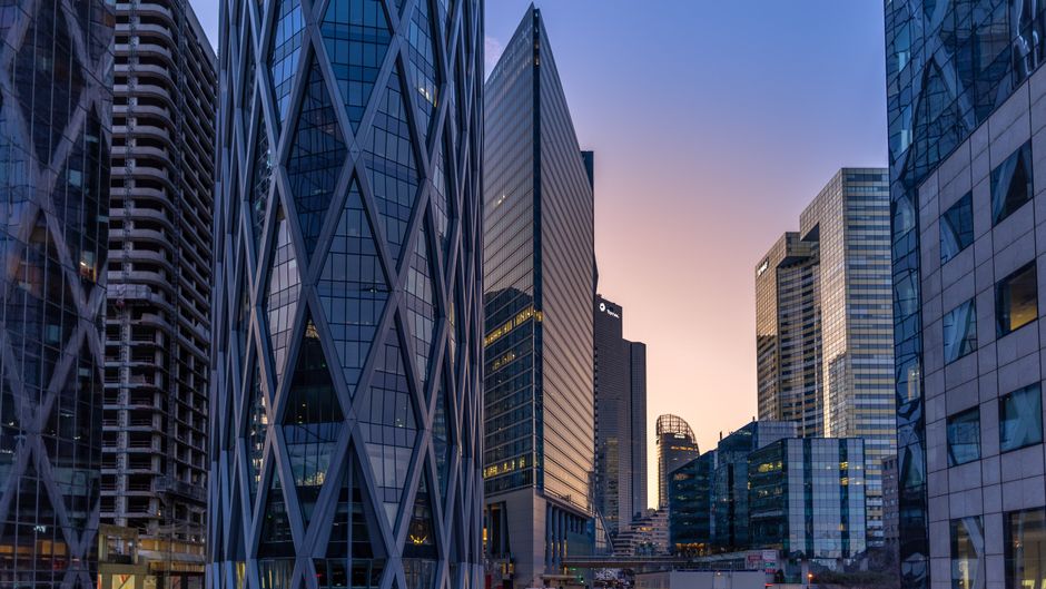 Modern curtain-wall skyscrapers at sunset in a financial district, representing the exchange ecosystem where SK hynix's ADRs will list.