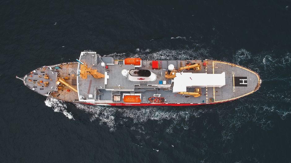 A cargo ship moves across open water as maritime passage becomes a key market risk.