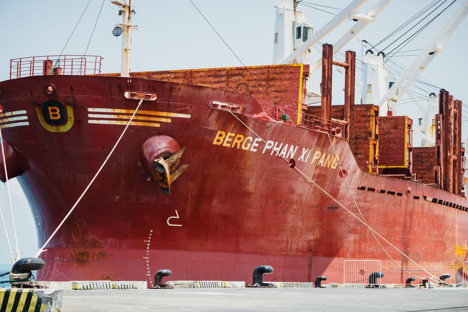 Large cargo ship docked at an industrial port.