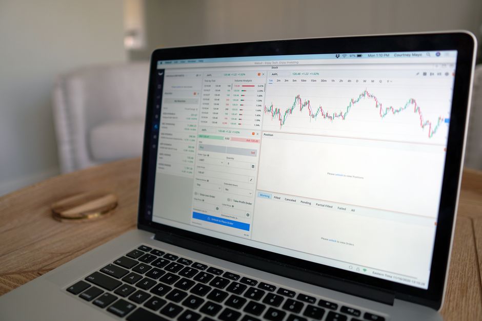 Laptop displaying stock trading software with a market chart.