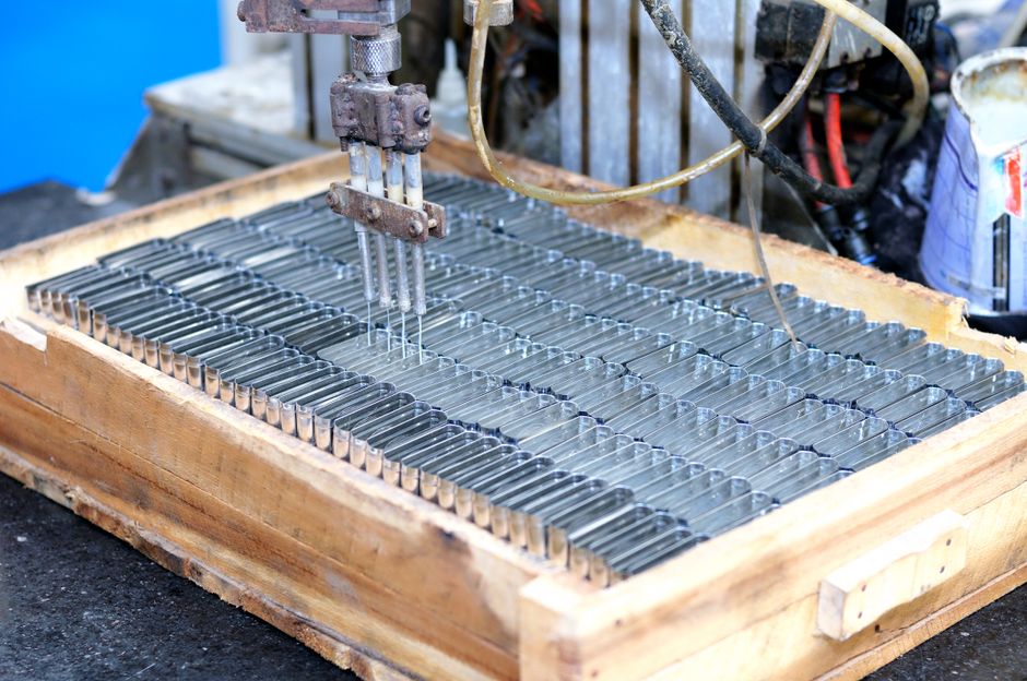 Automated industrial machinery processing parts, representing the semiconductor manufacturing cycle.