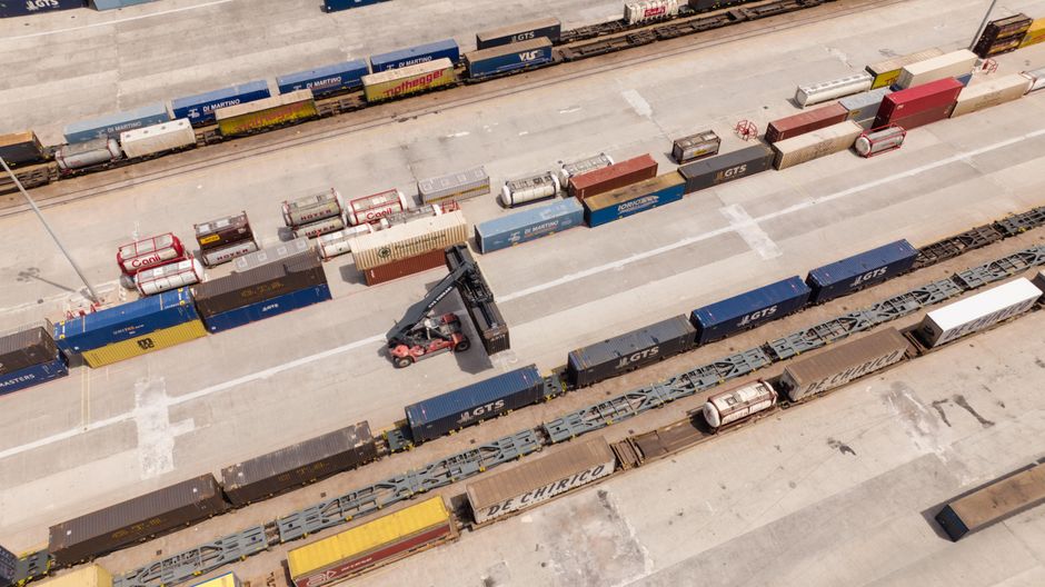 A logistics hub with stacked containers as geopolitical risk threatens energy and shipping flows.