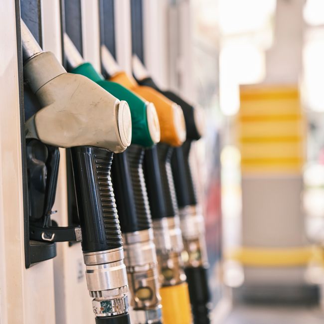 Colorful gas pump nozzles at a fuel station, representing the consumer-facing end of the oil market.