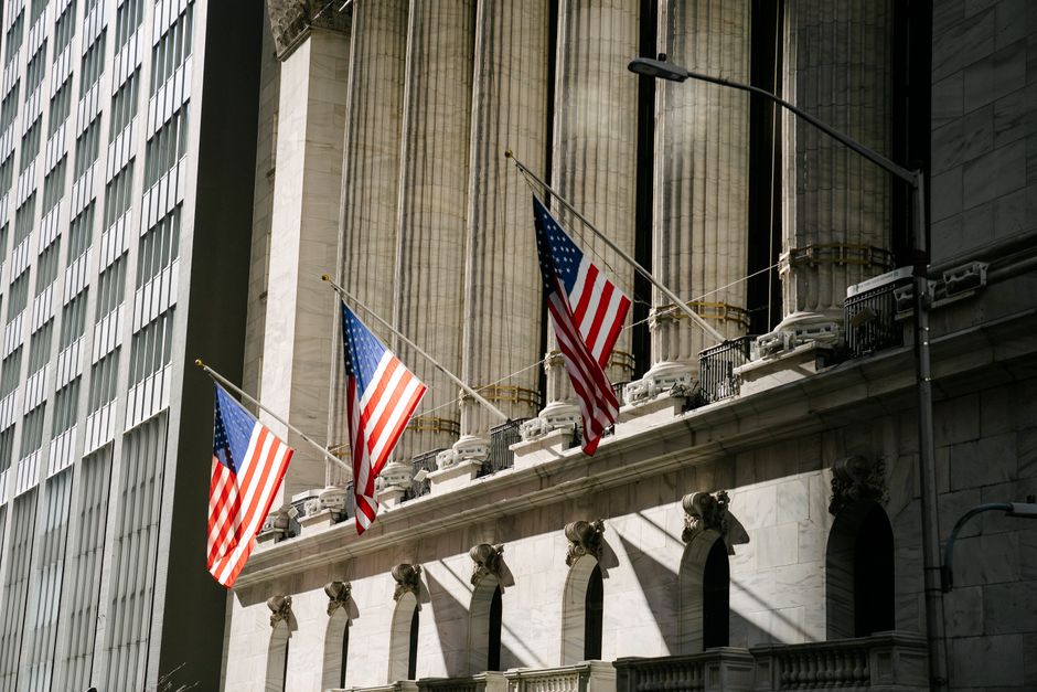 Grand architectural building with American flags outside, fronted by stone columns
