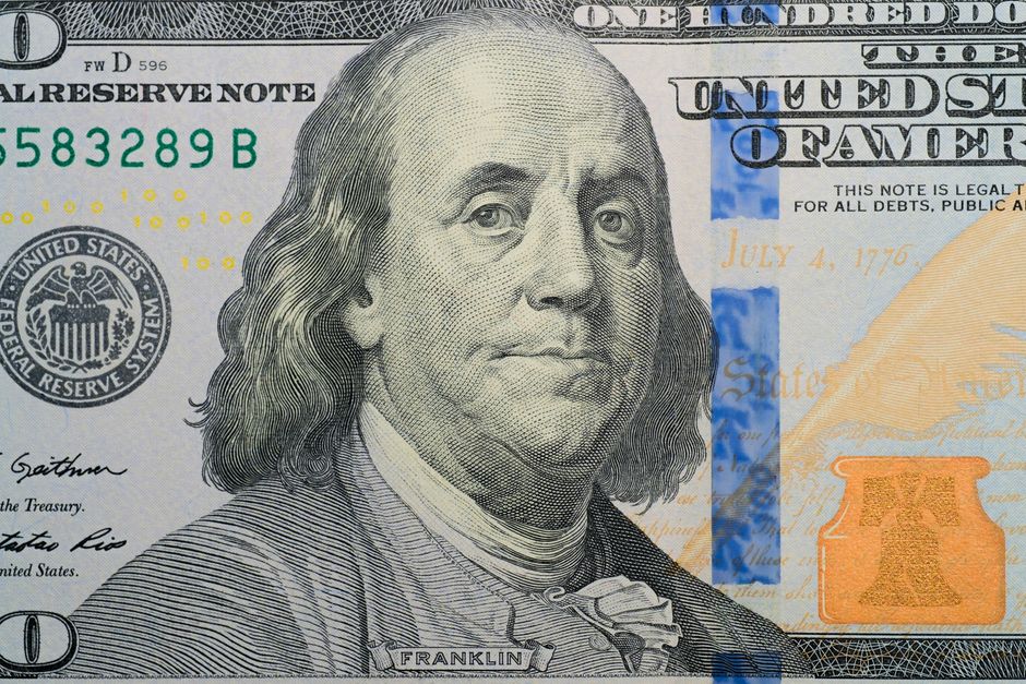 A close-up of a U.S. hundred-dollar bill bearing Benjamin Franklin's portrait