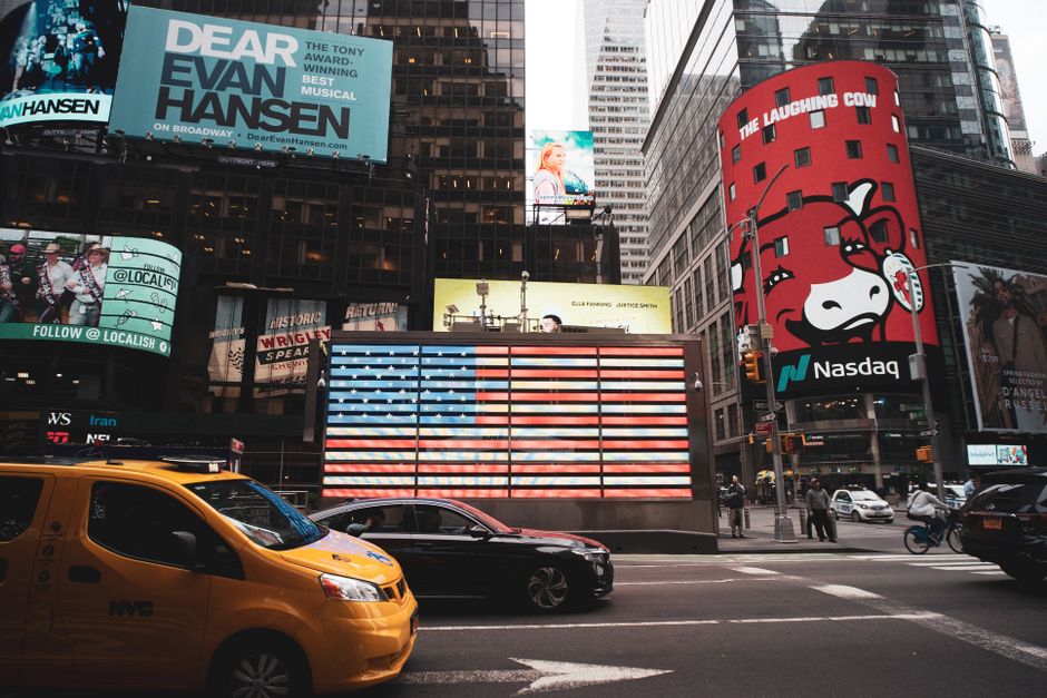 Times Square with billboards and yellow taxi in New York City