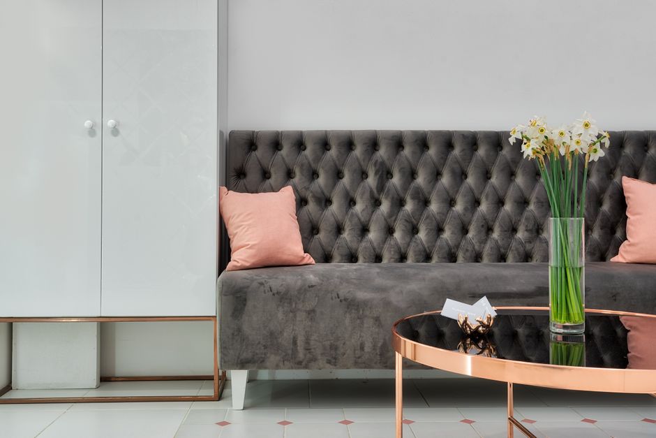 A modern interior with an upholstered sofa beside a low table and a vase of flowers