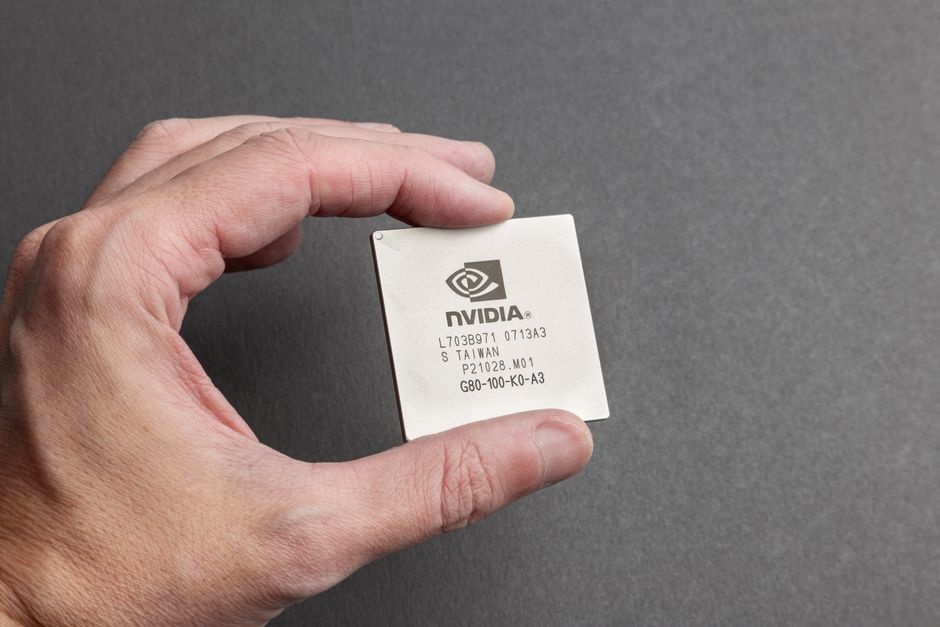 Close-up view of a graphics processing unit held in hand against a gray background
