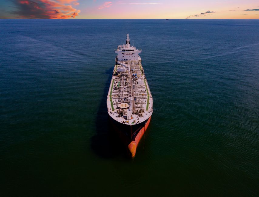 Aerial view of a large oil tanker ship traveling across the ocean, representing global energy shipping and crude oil transport.
