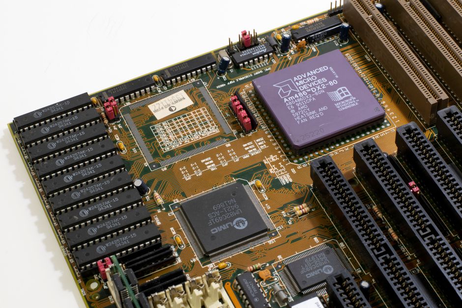 Close-up view of a computer motherboard with microprocessor and electronic components, representing semiconductor manufacturing.