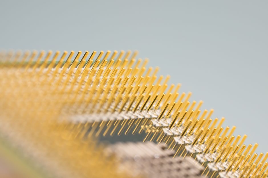 Close-up of gold CPU pins on a circuit board, showing fine electronic contacts