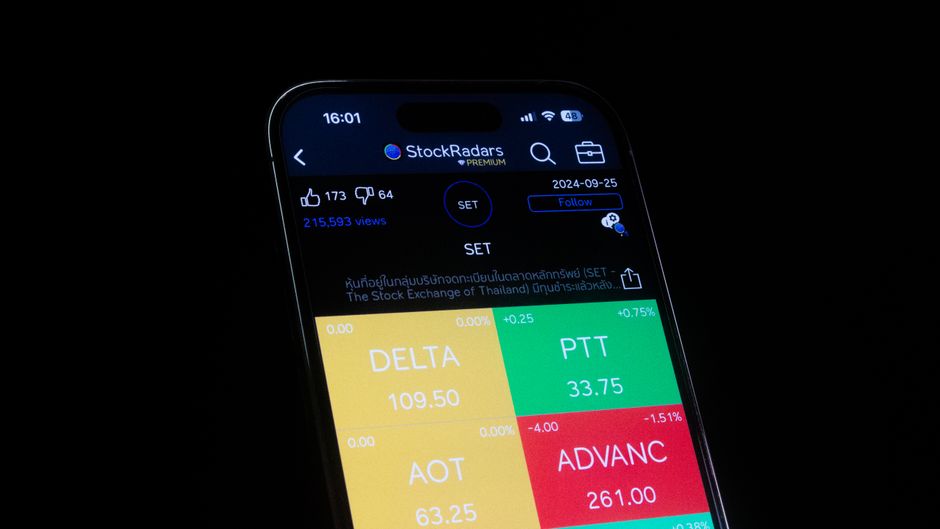 A close-up smartphone displays stock-market data in a financial application.