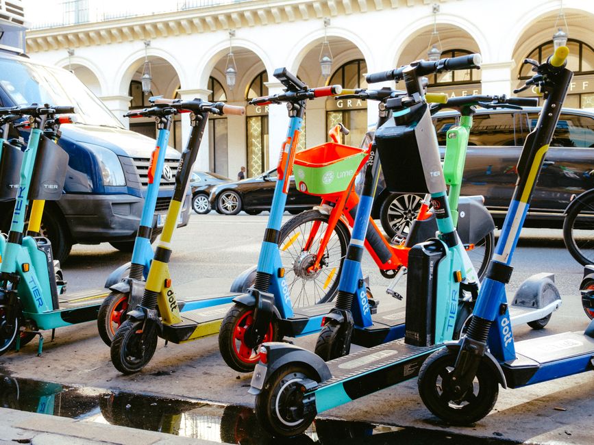 Electric scooters and bicycles parked on a city street