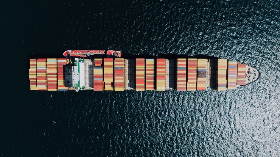Aerial view of a large cargo ship sailing on open ocean, representing commercial maritime traffic through strategic shipping lanes.