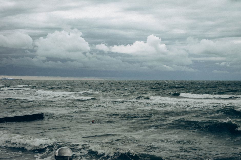 Moody ocean scene with stormy waves and dark clouds over the sea, representing turbulent maritime conditions at critical shipping chokepoints