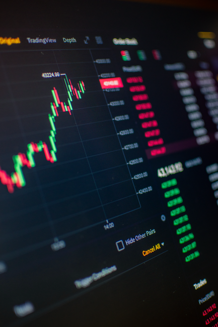Close-up of a digital screen showing financial market trading data and graphs.