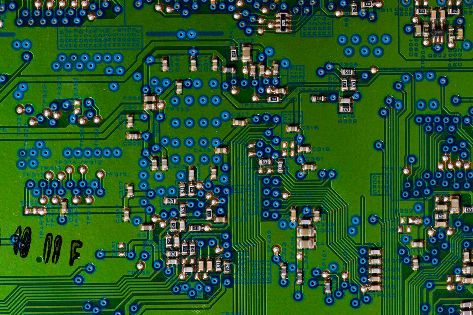 A close-up of a green circuit board with electronic components, representing semiconductor manufacturing underlying CXMT's IPO