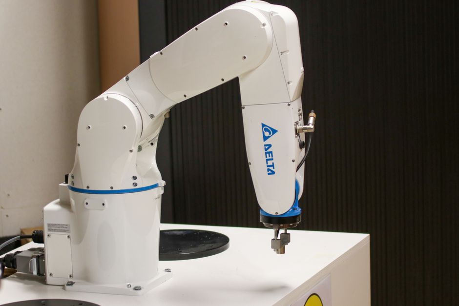 Industrial robotic arm in an automated manufacturing setup, representing advanced semiconductor fabrication