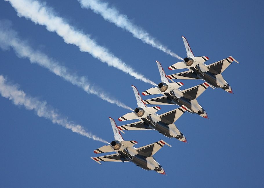 Four fighter jets in formation flight against a clear sky