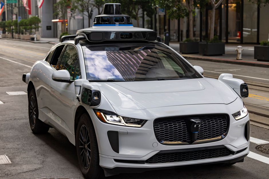 A white autonomous vehicle navigating a city street