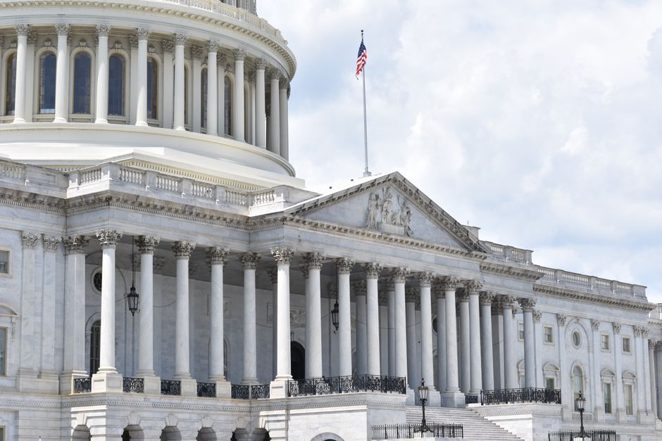 U.S. Capitol building with neoclassical architecture and American flags in Washington, DC