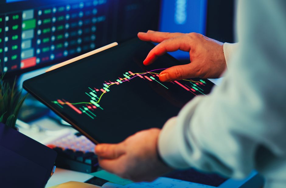 Market professional reviewing financial charts and electronic trading data