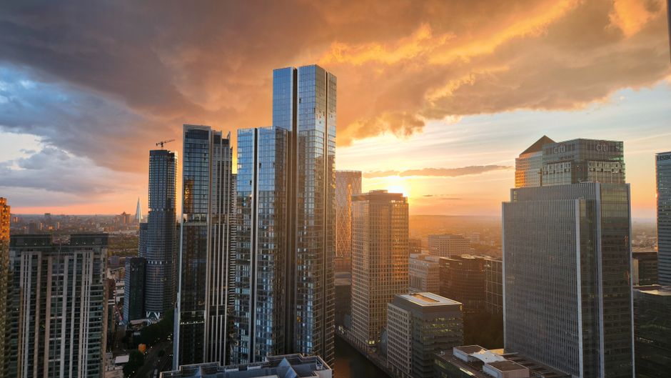 Financial district skyscrapers against a vibrant sunset sky, representing the capital markets backdrop for new issuance.