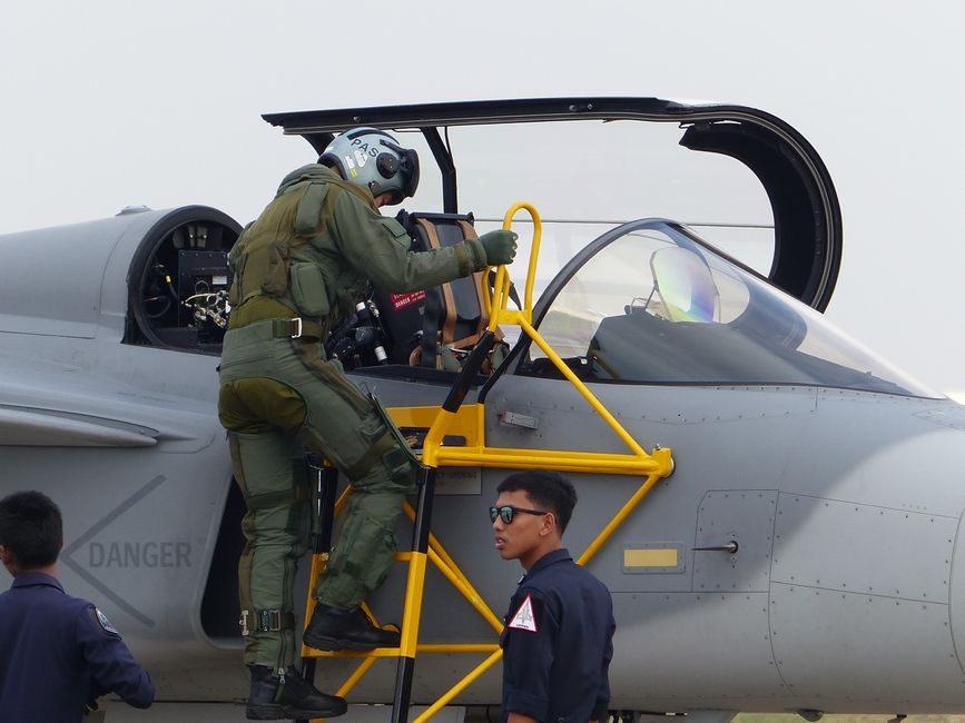 Military pilot climbing into fighter jet cockpit