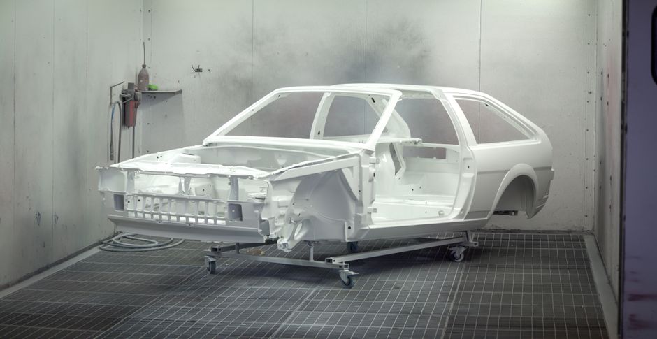 Car body in an automotive paint booth
