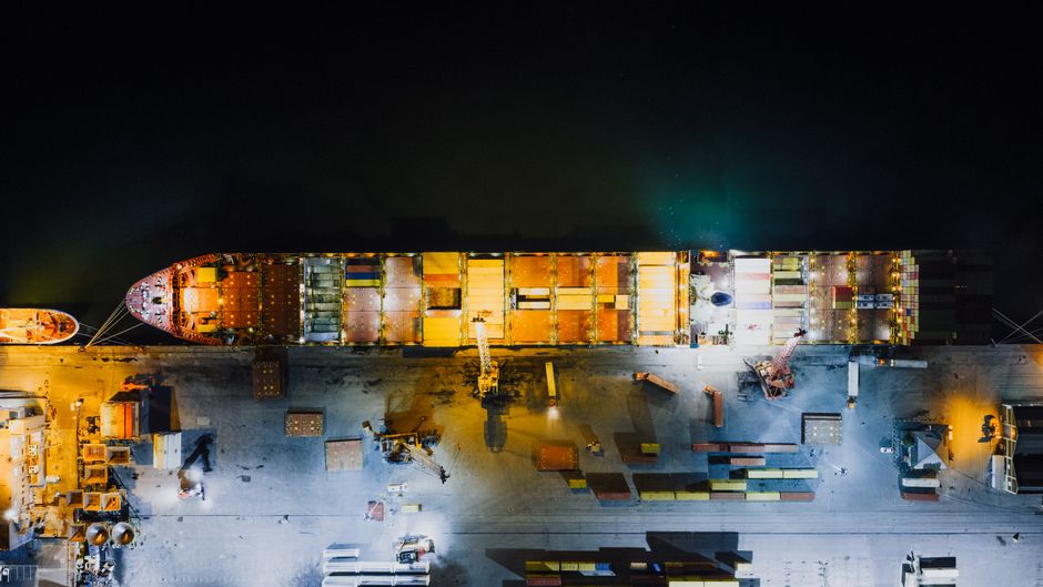 Cargo ship at a major port as maritime rerouting raises energy and freight risks.