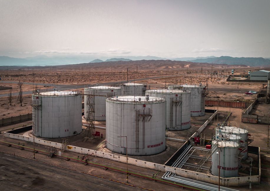 Aerial view of industrial oil storage tanks in a desert landscape