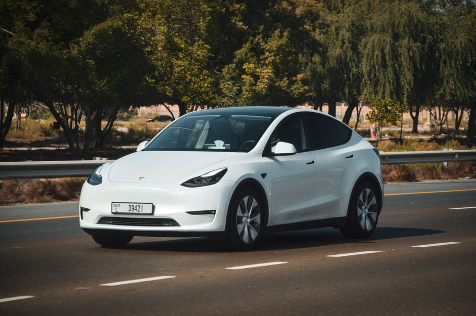 Sleek white electric car cruising on a sunny highway