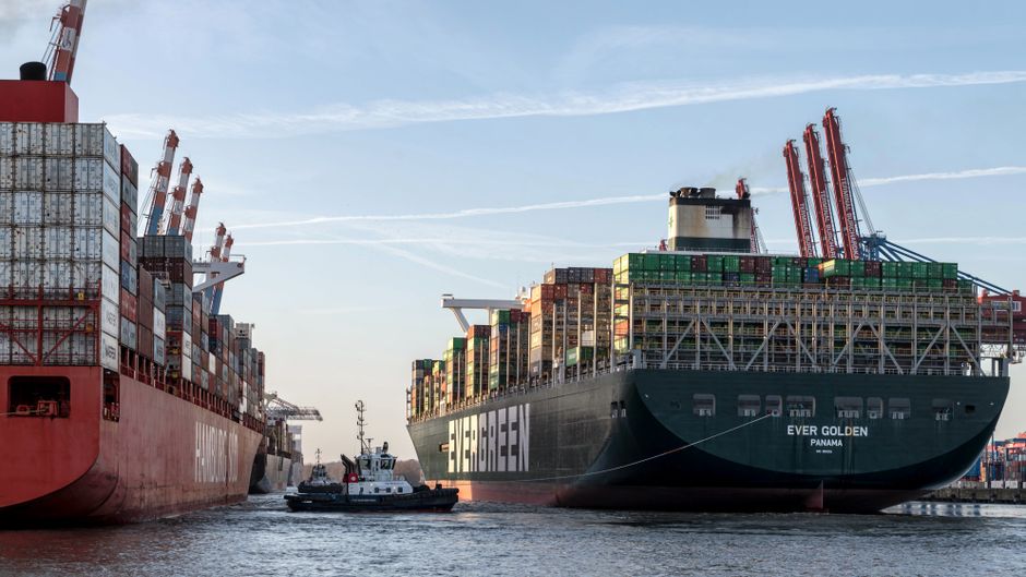 Container ships in a busy port loaded with cargo, illustrating commercial shipping traffic through a critical maritime chokepoint.