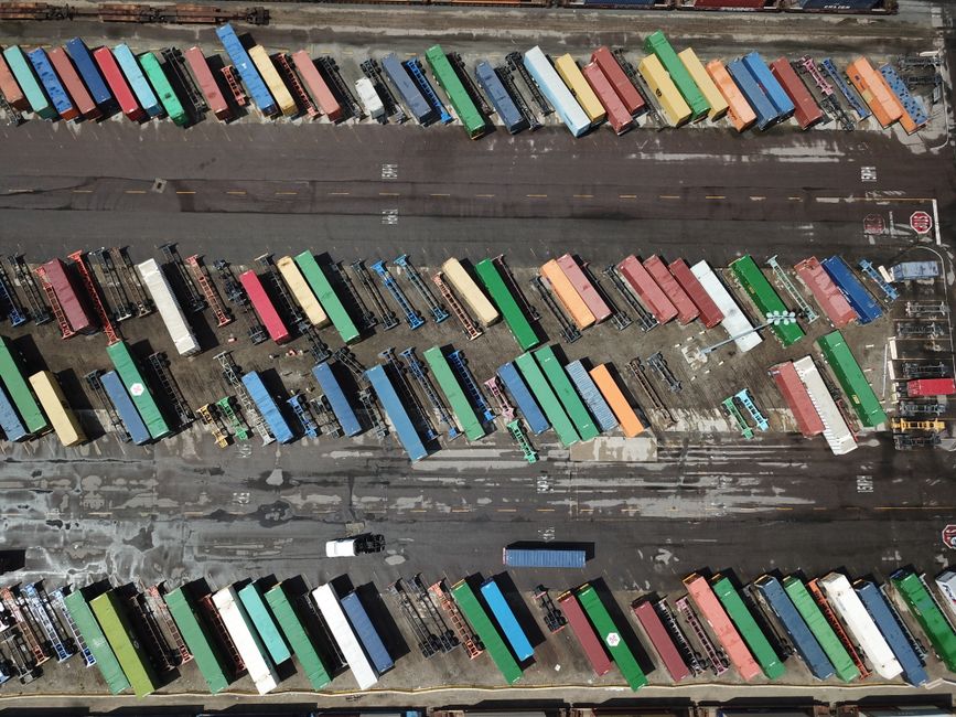 Aerial shot of multicolored shipping containers in an organized layout at a port