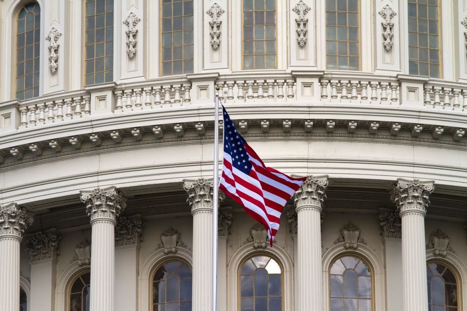 Close-up of the American flag waving outside a government building in Washington, DC.