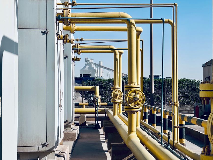 Industrial pipeline system with valves and steel piping in a Middle Eastern oil facility.