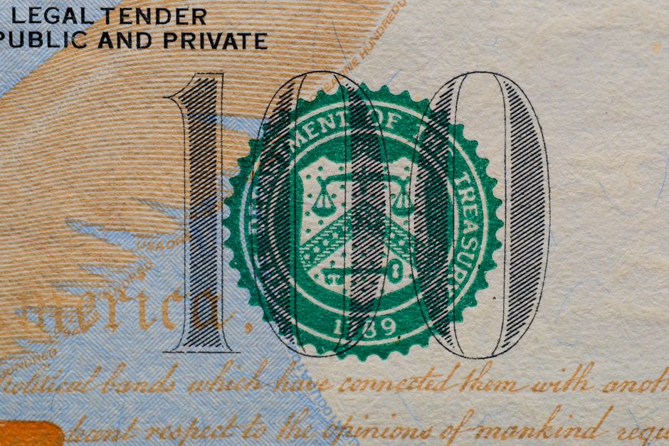 Close-up of a US hundred-dollar bill bearing the Treasury seal