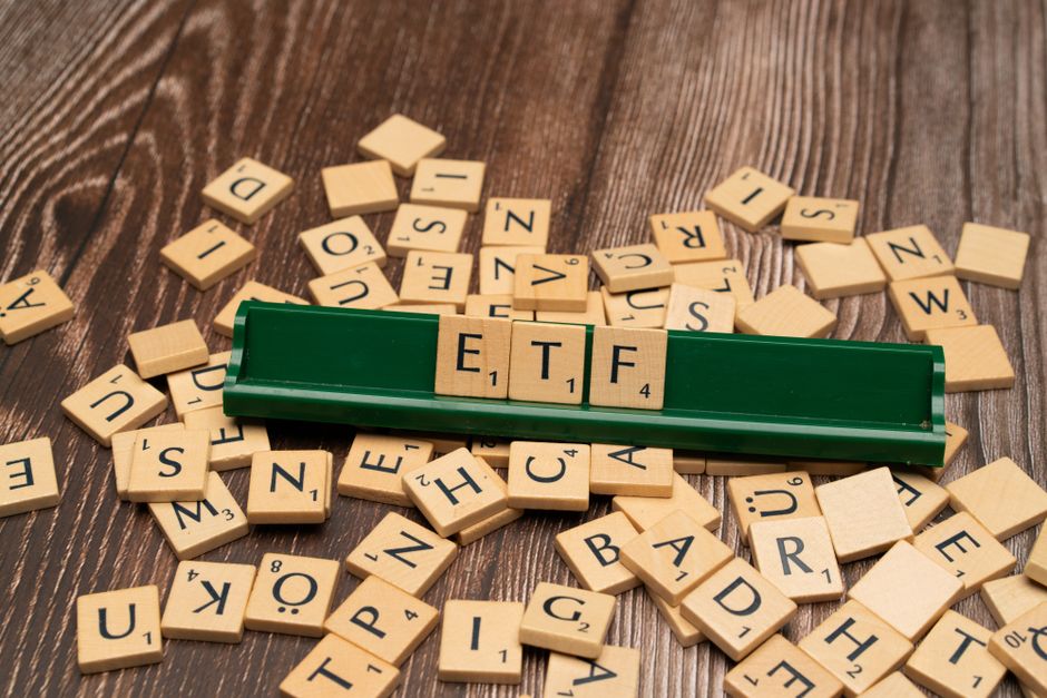 Wooden letter tiles spelling ETF on a holder board