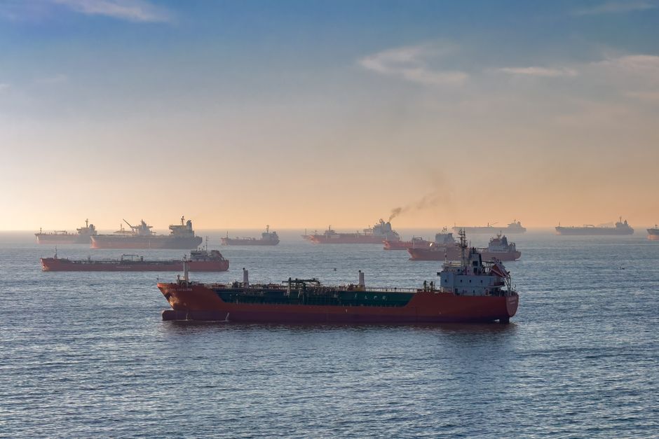 Oil tankers and cargo ships transit a major shipping strait at sunset